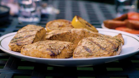 Multiple Grilled salmon served on a plate with a lemon wedge