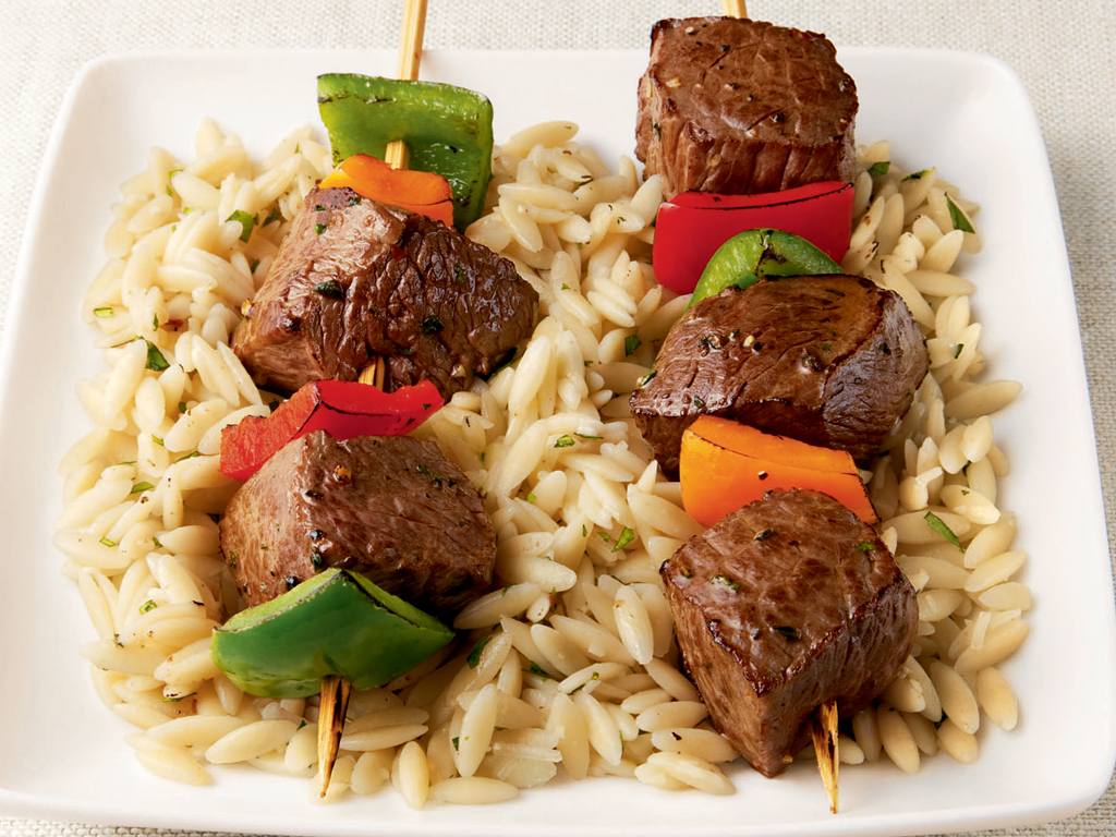 2 beef kabobs on bed or orzo pasta