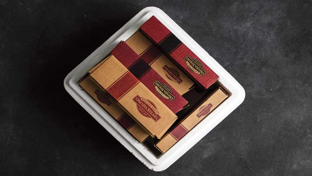 omaha steaks white cooler with 5 boxes of product inside with black background