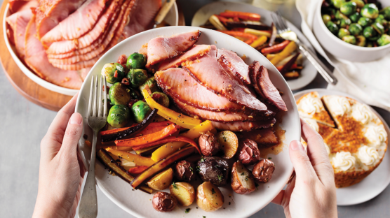 Plated Easter dinner with ham, tri-color potatoes, carrots and brussels sprouts