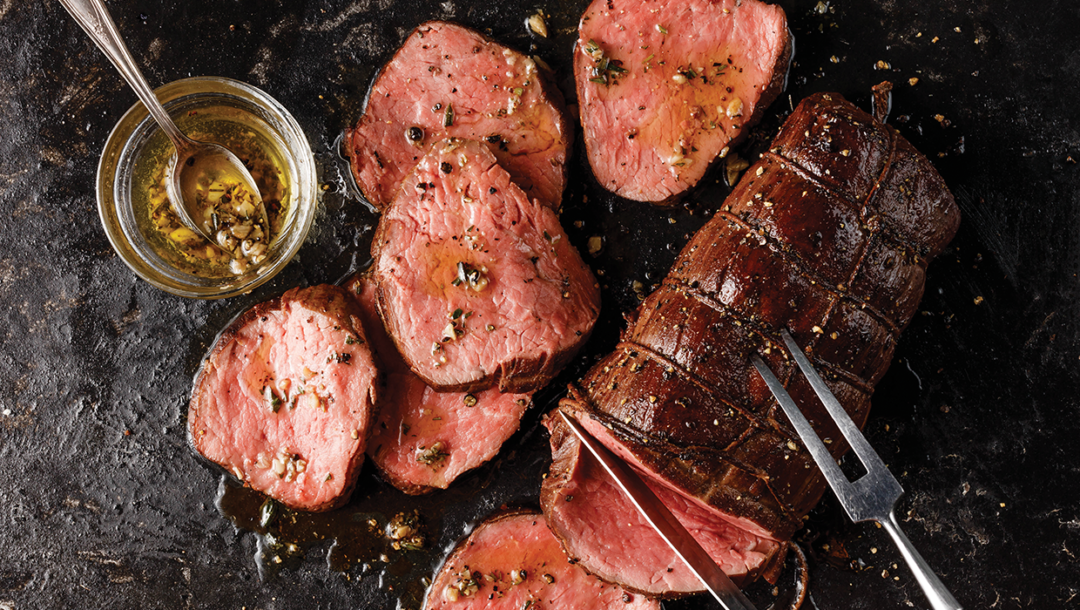 chateaubriand roast sliced with butcher's butter in bowl with serving spoon