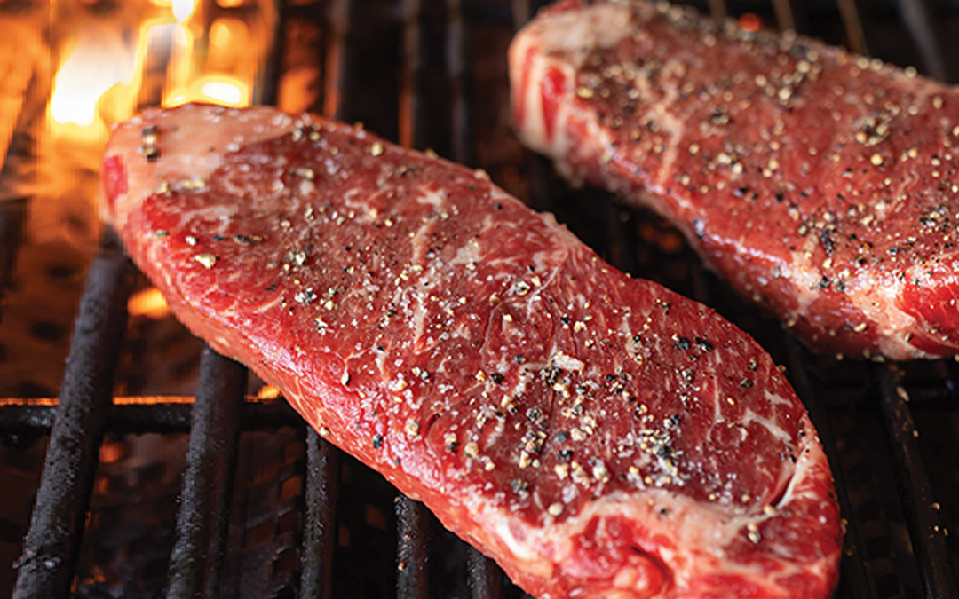 Two New York strip steaks on grill