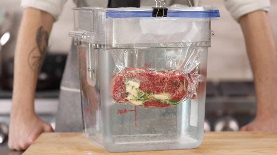 Steak in bag with butter and herbs cooking in immersion circulator
