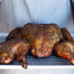 Man holding spatchcocked and smoked turkey