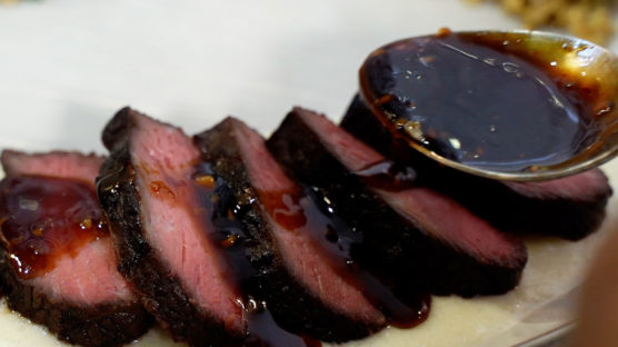 Pouring sweet soy sauce over sliced top sirloin