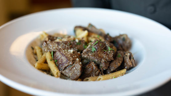 Traditional Italian pasta dish aglio e olio with beef sirloin tips, pasta, garlic, Parmesan cheese and a blend of seasonings.