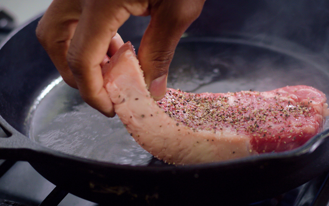 Cooking a New York strip steak in a cast iron pan indoors with Chef David Rose