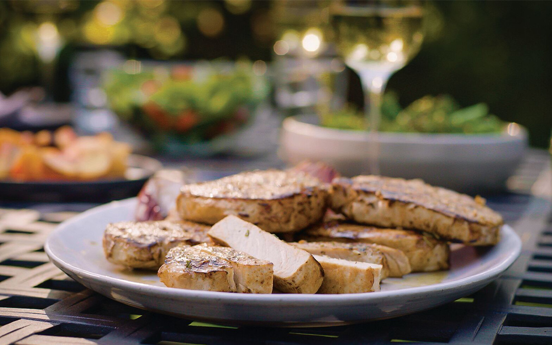 Perfectly grilled pork chops on a plate at an outdoor barbecue