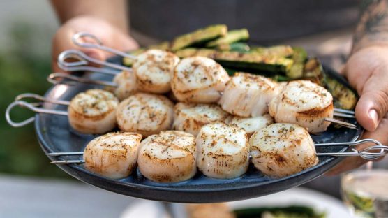 Perfectly grilled colossal scallops double skewered and served on a plate