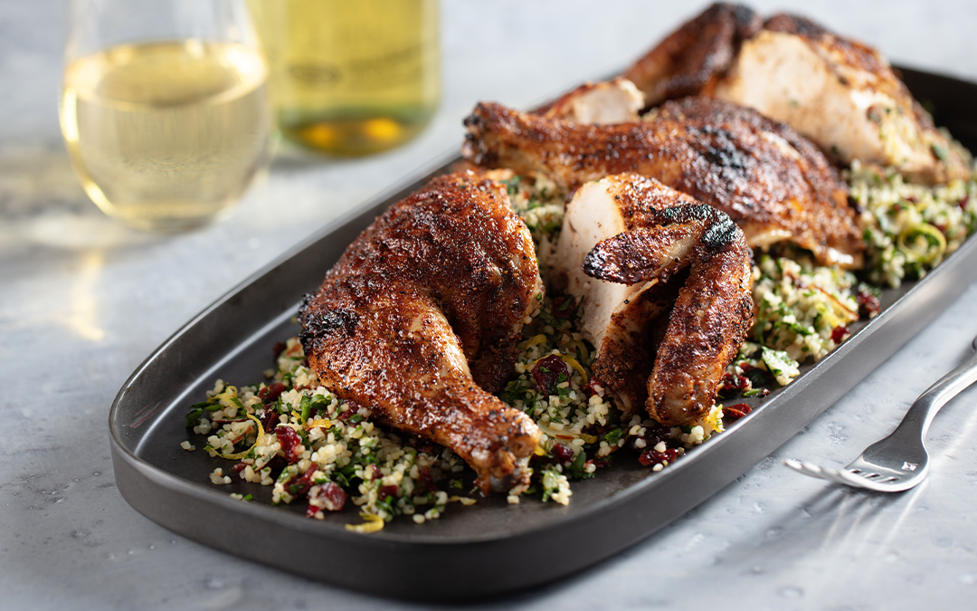 Family platter of grilled moroccan-spiced spatchcock chicken served with dried cherry tabbouleh salad and beverages