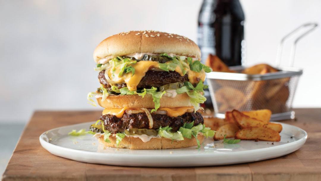 The Mack NY strip burger recipe served on a plate with wedge potato fries