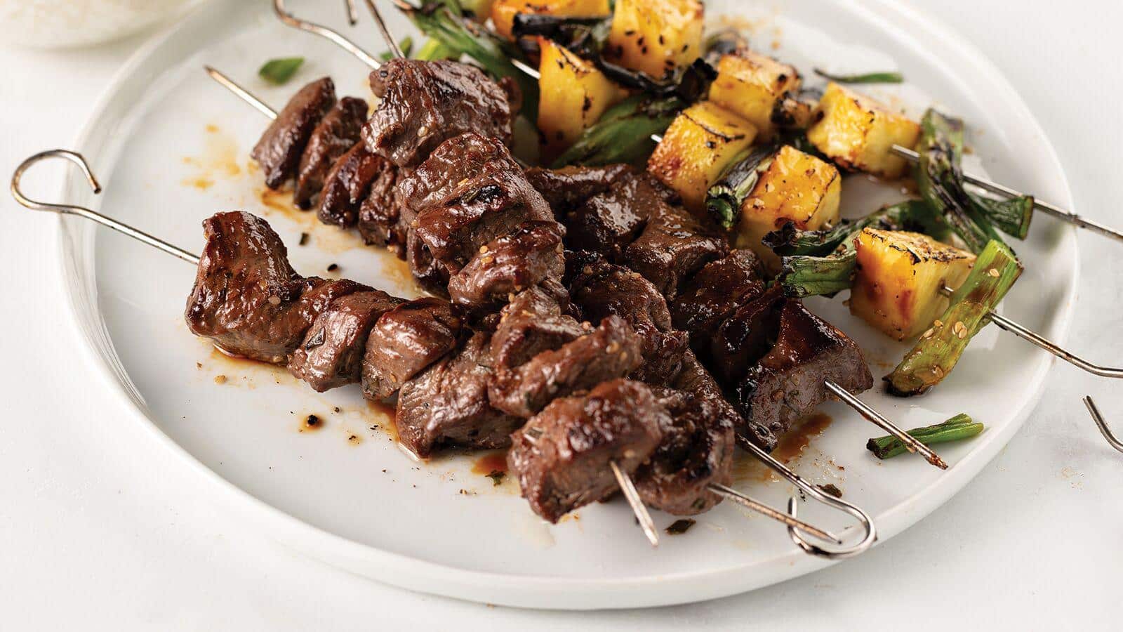 Reverse seared, medium-rare sliced filet mignon served with creamy orzo pasta with pancetta and topped with caponata