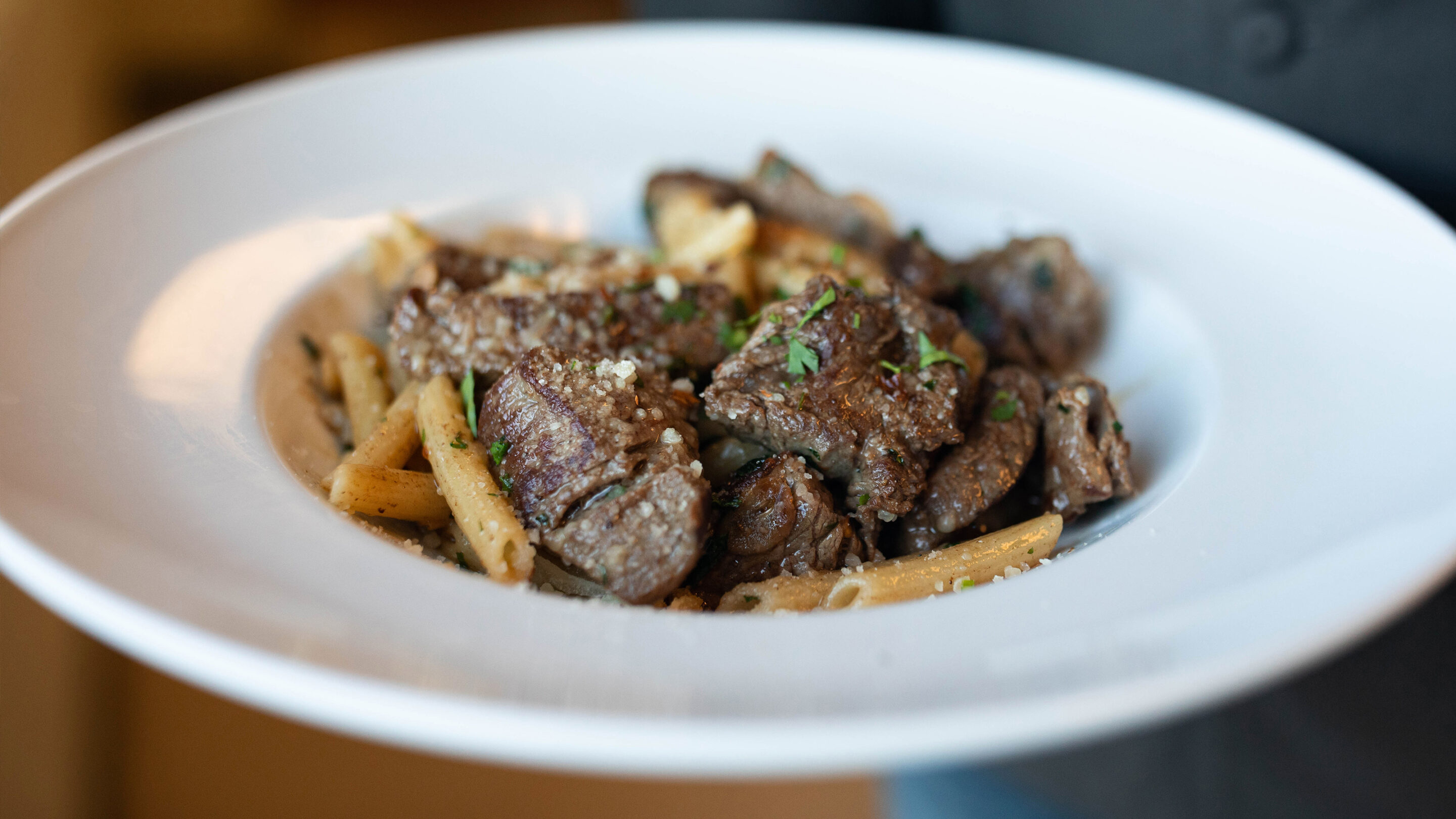 white bowl with aglio e olio beef sirloin tips.