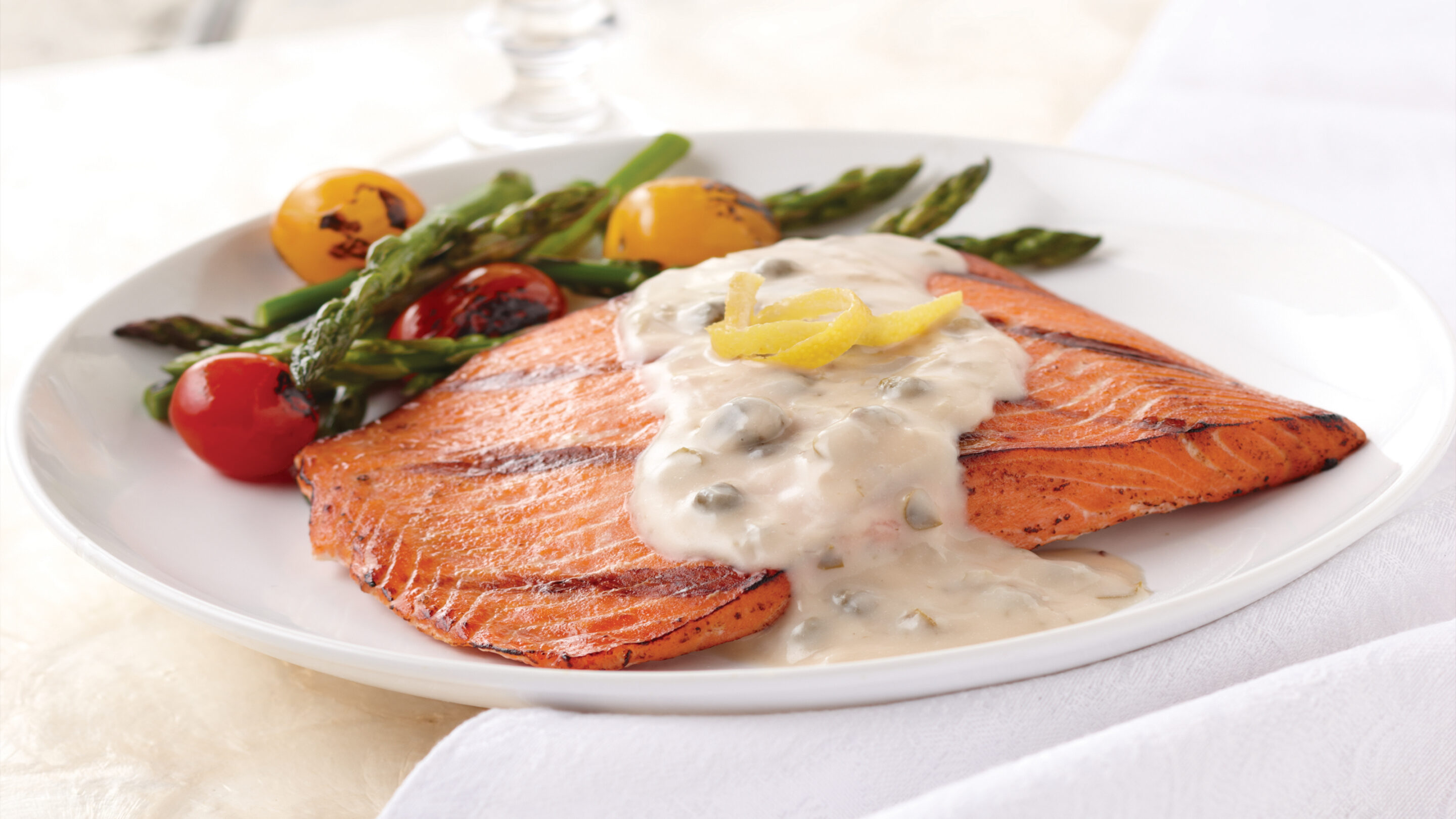 salmon filet with lemon caper beurre blanc sauce served with asparagus spears