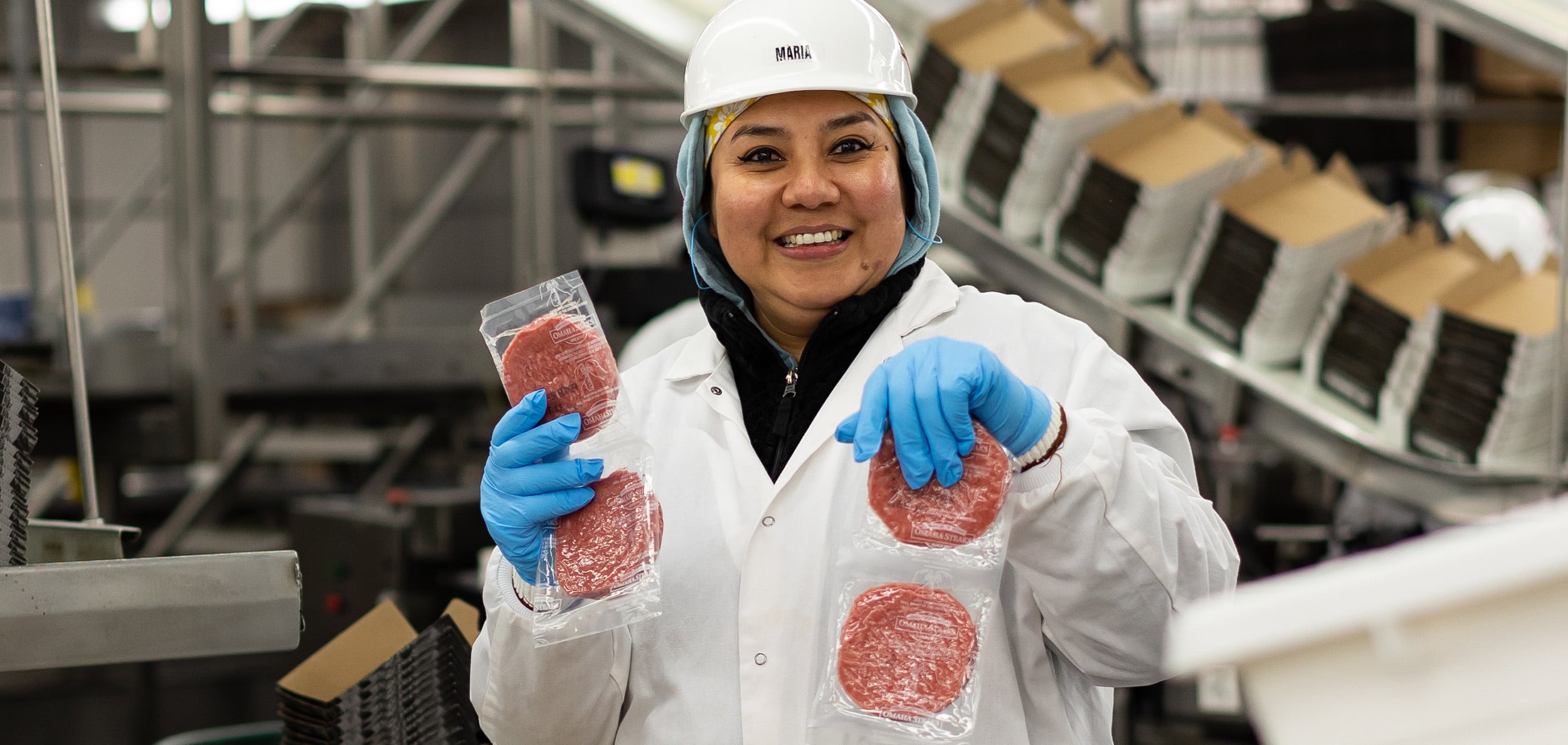 omaha steaks employee in plant holding packaged hamburger patties