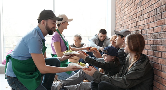 group of young people receiving food from volunteers