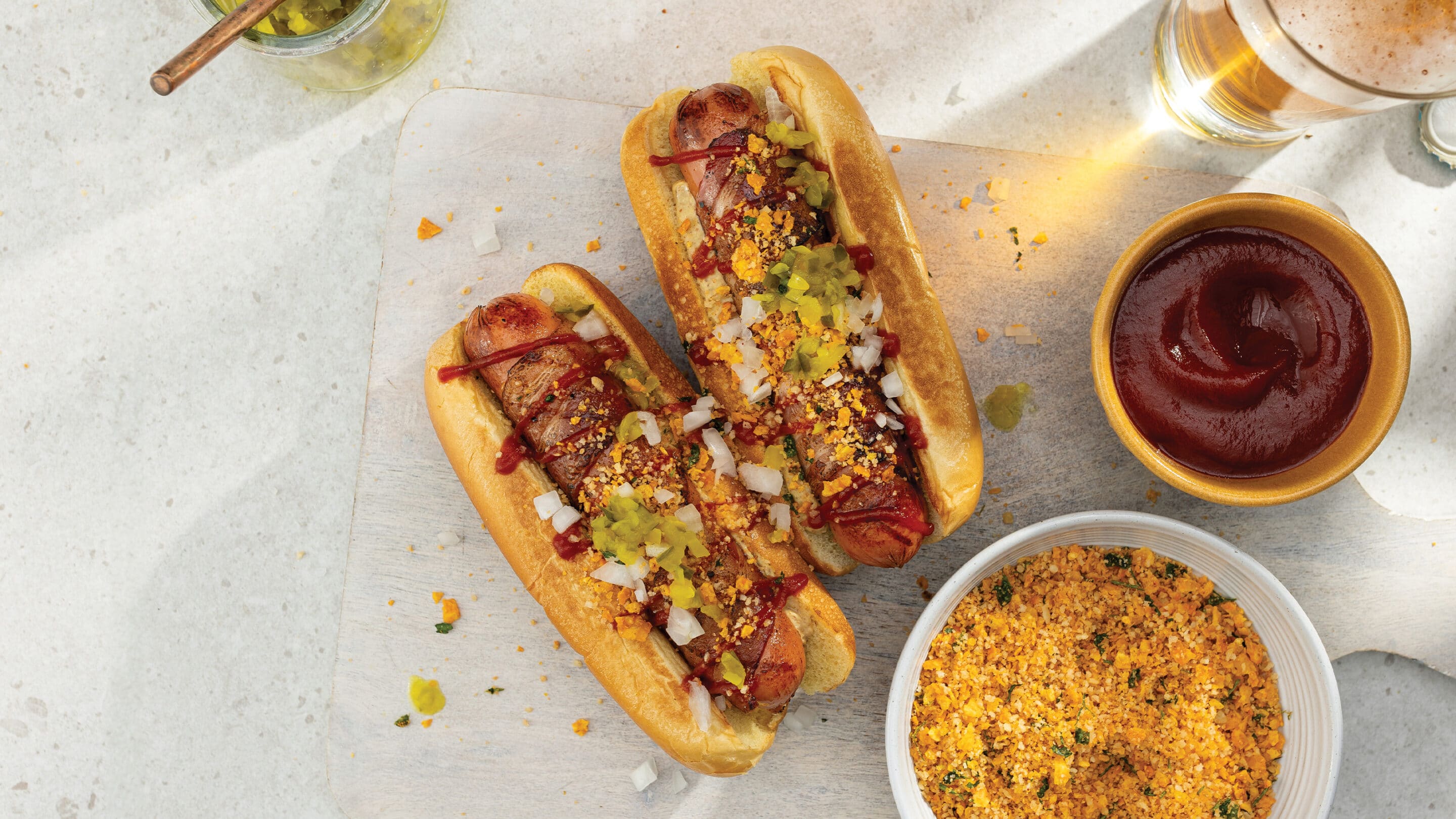 Two bacon-wrapped franks loaded with toppings and a crispy tortilla chip crumble. 