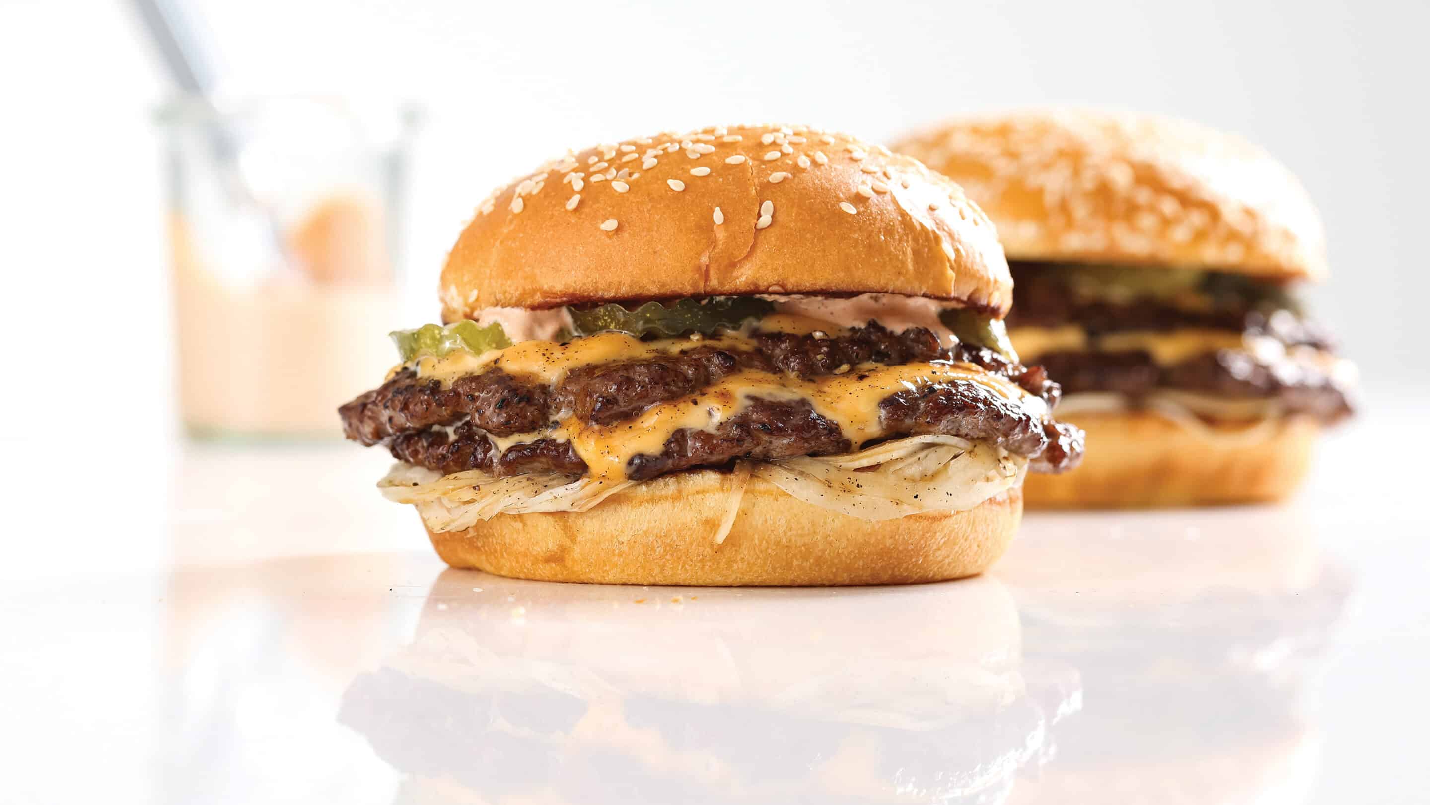 Two Omaha Steaks smash burgers with image of sauce in background